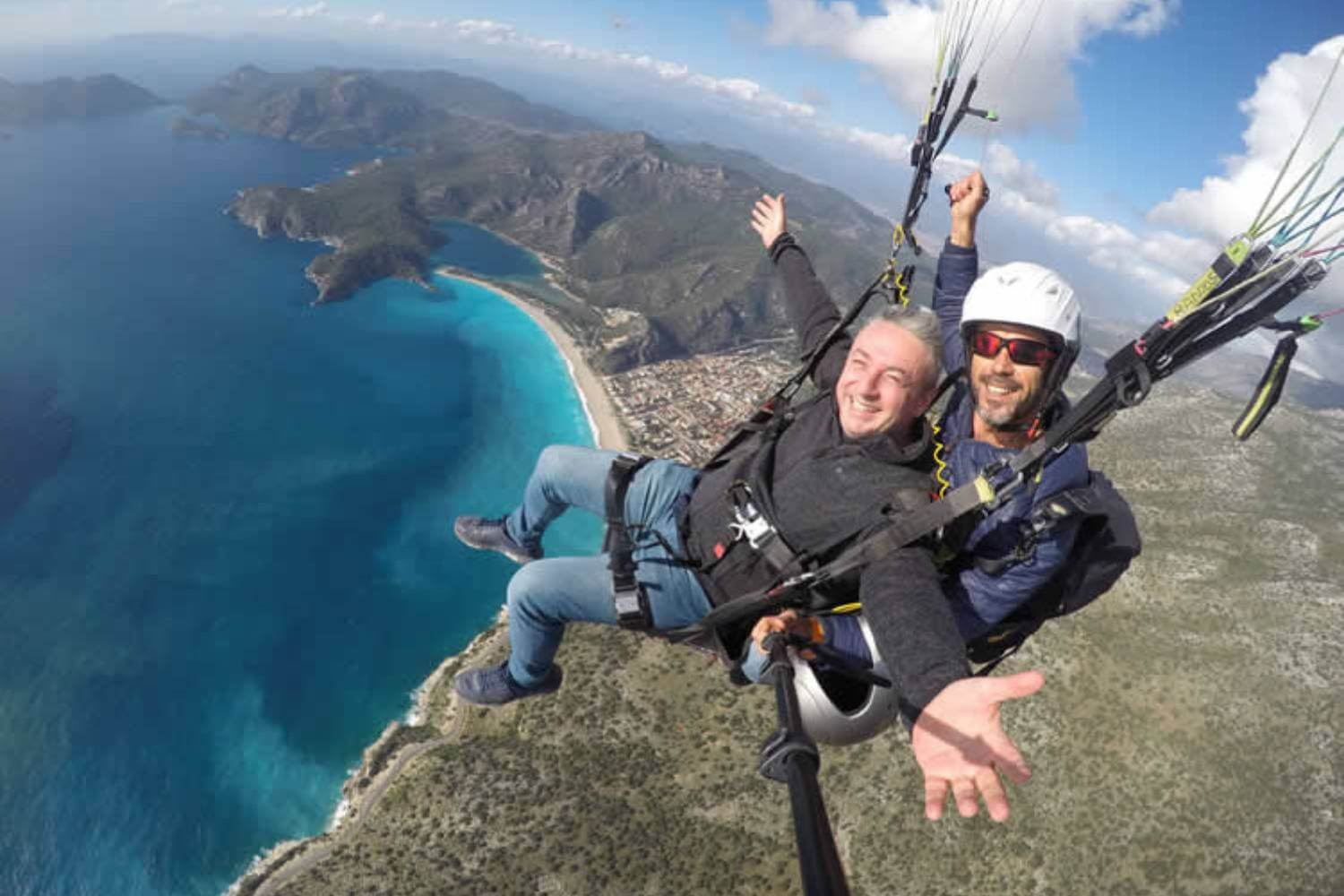 Paragliding in Fethiye Oludeniz. The first stage of this journey starts with climbing to the top of Baba Dag which is 6,500 feet above sea level with our specialy designed Trucks which roughly takes about 30 minutesride. Ones up, you will receive all the necessery information you need from our qualified and skilled pilots. You will be supplied with appropriate boots and helmet. You may be supplied with a flying suit if the weather is a bit chillier then usuall. Feel free to bring along your own boots if you wish to.