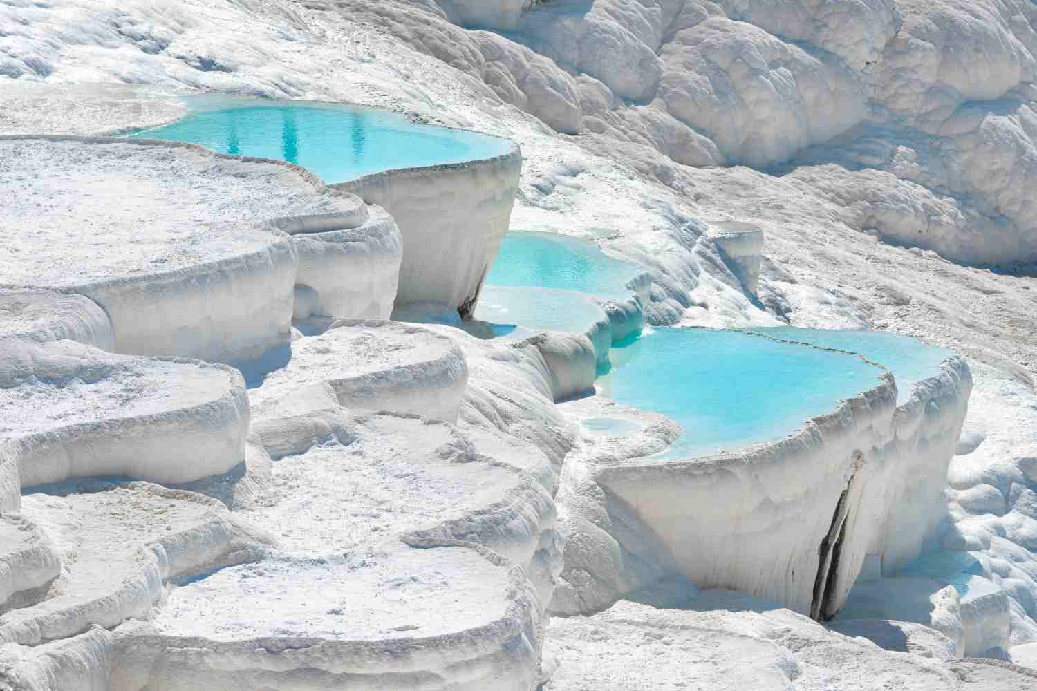 Excursion to Pamukkale from Dalaman area, Pamukkale is one of the most exquisite displays of the beauty of nature that you can imagine. White travertine terraces of bright blue water and snow-white limestone decorate the valley sides of Pamukkale, known as the ‘Cotton Castle’. These unique natural formations make a trip to Pamukkale an unmissable highlight of any tour of Turkey. These natural pools were formed as a result of centuries of limestone erosion by thermal springs, and the mineral-rich water of Pamukkale’s pools have long-since attracted visitors thanks to their reputedly therapeutic properties. Hierapolis, the ancient city built around Pamukkale’s natural pools, pays testament to this, as it was constructed around the 2nd-century BC as a spa town to make the most of the warm, mineral-rich waters of this region.